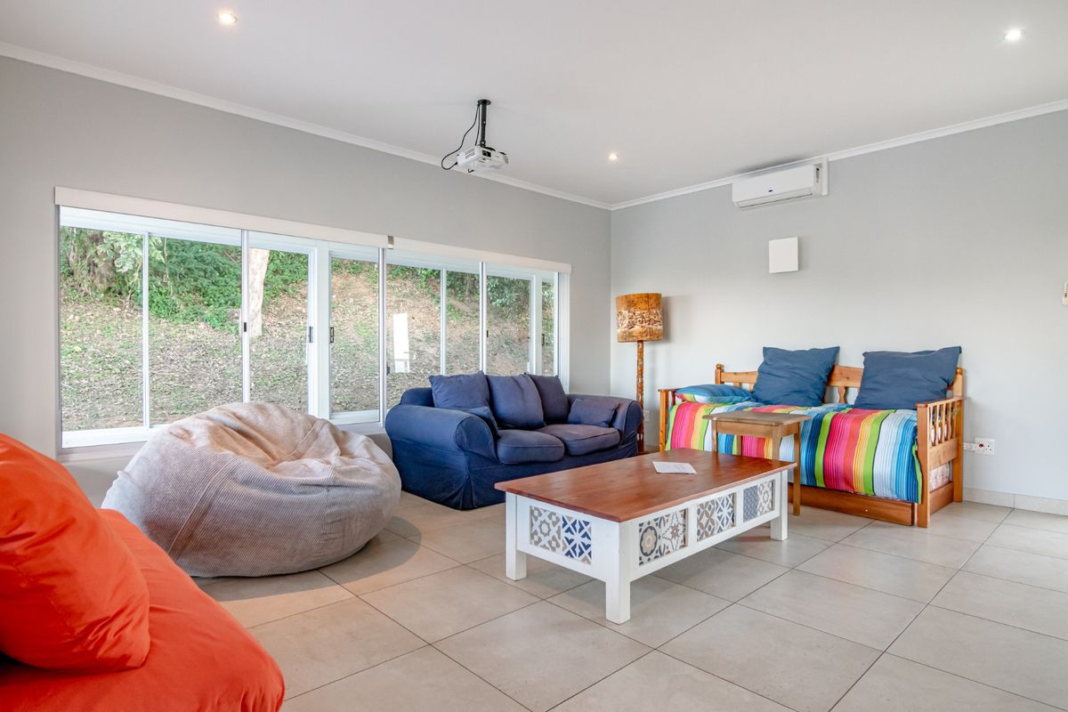 Spacious living area featuring large sliding glass doors, tiled flooring, recessed lighting, and a wall-mounted air conditioning unit.