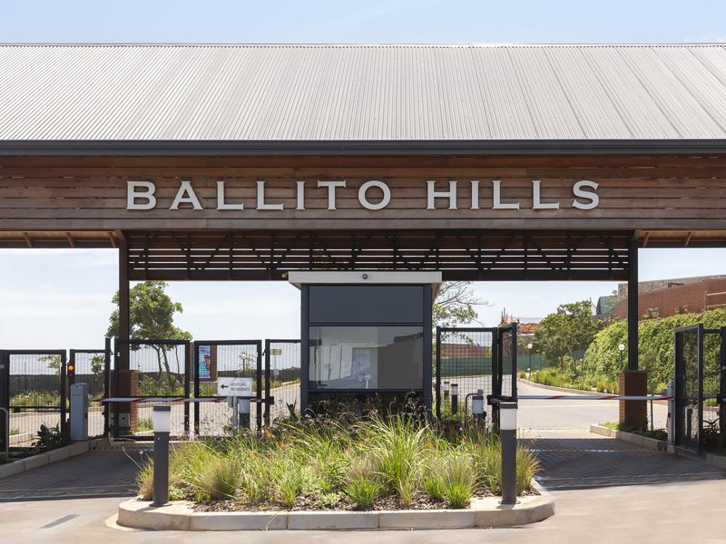 The main entrance gatehouse of Ballito Hills, featuring a modern timber-clad structure, secure boom gates, and well-maintained landscaping.