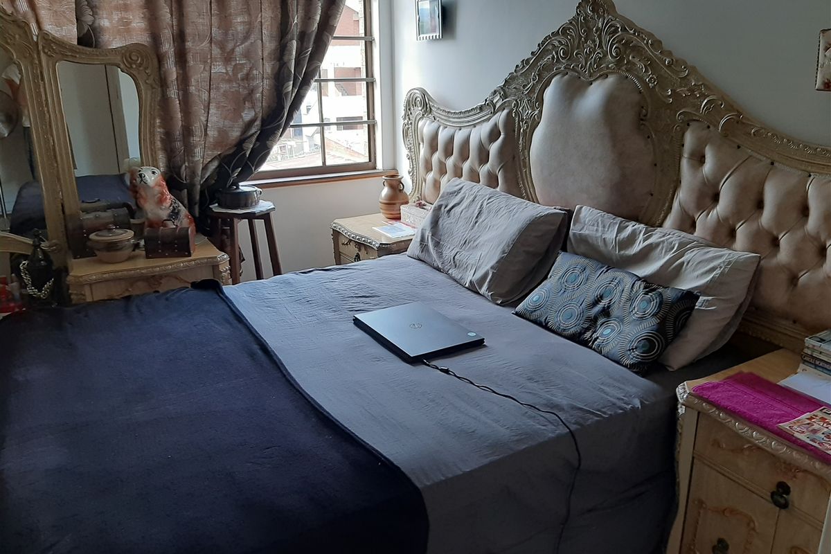 A bedroom featuring a window with curtains and neutral wall finishes.