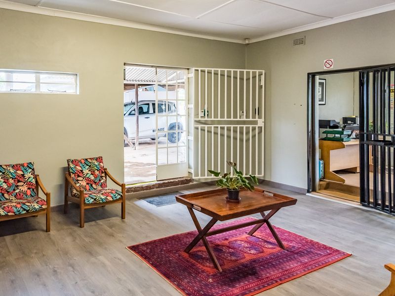 A functional entrance area featuring laminate flooring, a stone fireplace detail, and secure access points with fitted security gates.