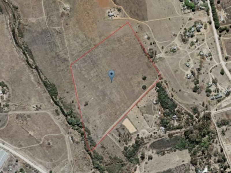 An aerial view of a large, vacant commercial land plot with a red boundary outline indicating the property perimeter.