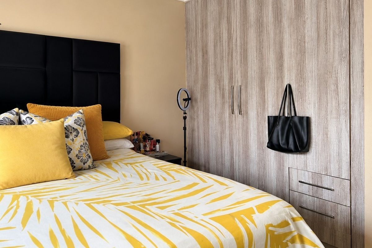 A bedroom featuring light wood-grain built-in cupboards with integrated drawers, providing ample storage space.