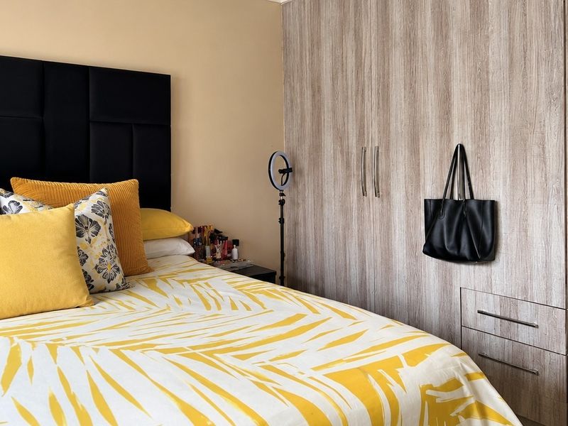 A bedroom featuring light wood-grain built-in cupboards with integrated drawers, providing ample storage space.