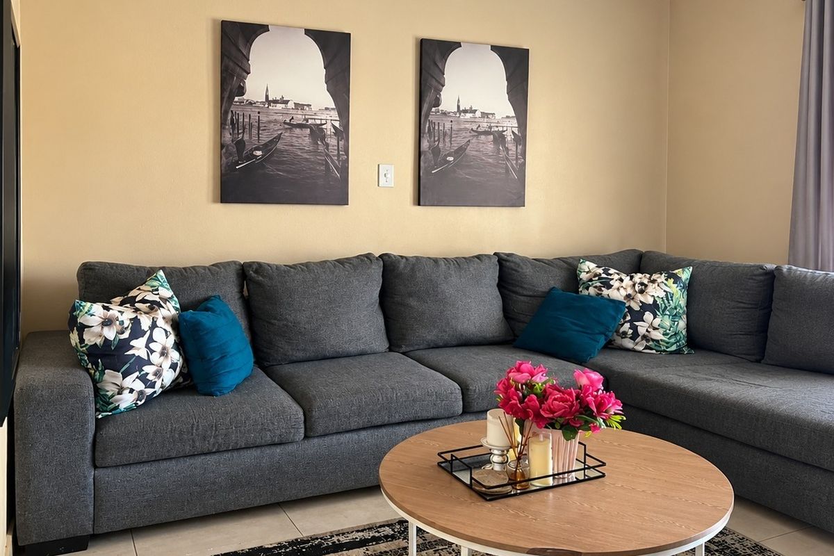 A comfortable living room area featuring neutral wall tones and tiled flooring, providing a functional and inviting space for relaxation.