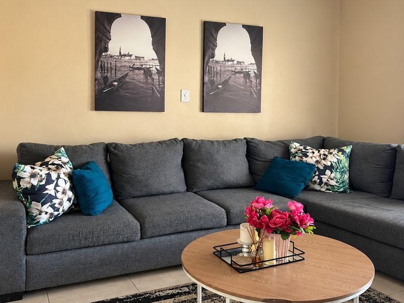A comfortable living room area featuring neutral wall tones and tiled flooring, providing a functional and inviting space for relaxation.