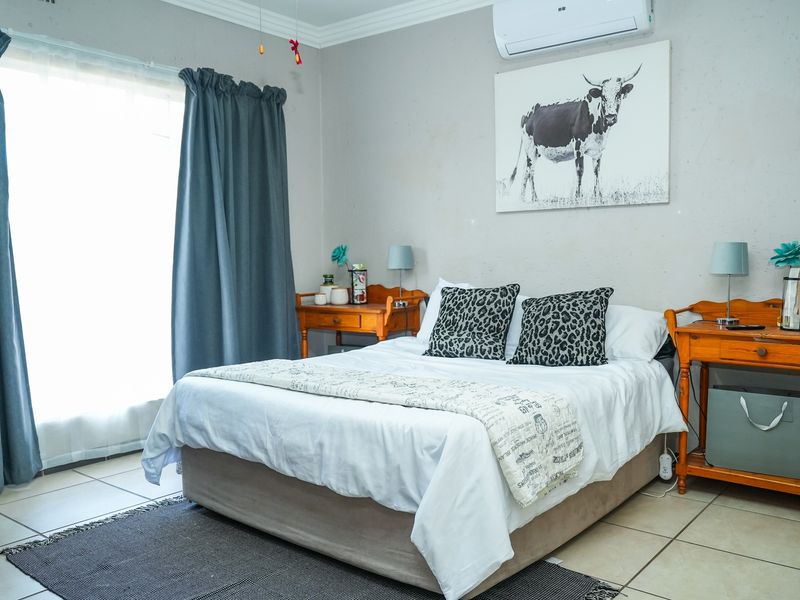 A bedroom featuring tiled flooring, a wall-mounted split-system air conditioner, and decorative cornice detailing.