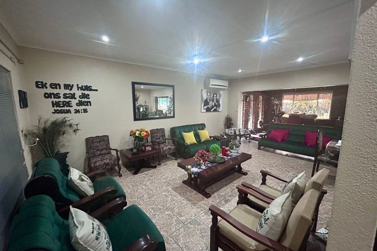 Spacious living area featuring ceramic floor tiles, recessed downlighting, and a wall-mounted split-system air conditioner.