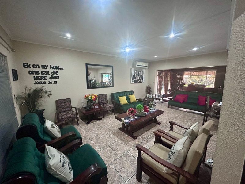 Spacious living area featuring ceramic floor tiles, recessed downlighting, and a wall-mounted split-system air conditioner.
