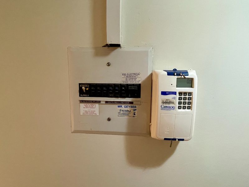 Wall-mounted electrical distribution board and prepaid electricity meter unit.