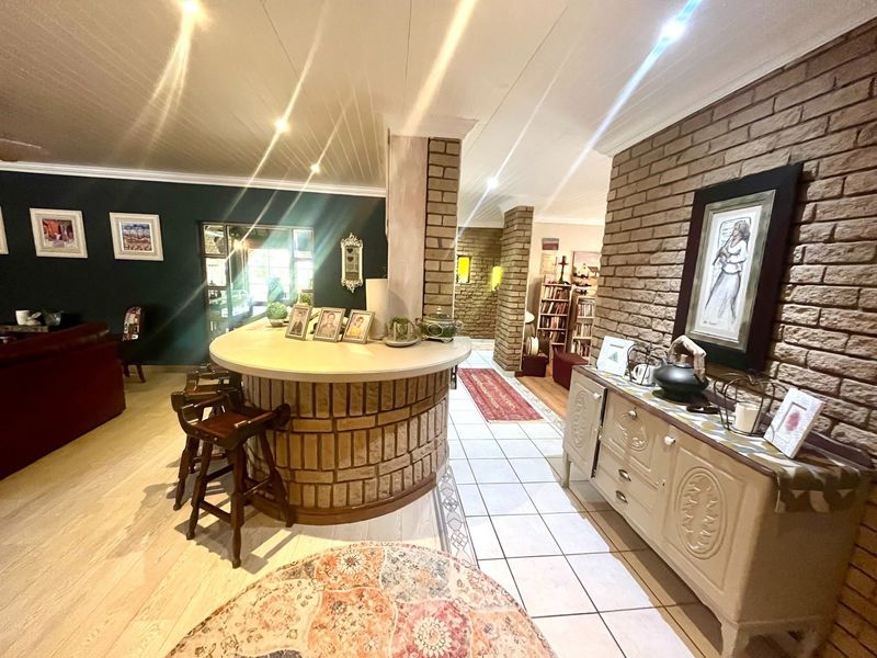 Spacious open-plan living area featuring a unique built-in brick bar, contrasting brick feature walls, and a combination of tiled and laminate flooring.