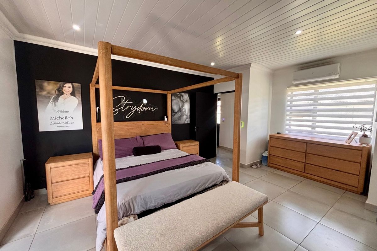 Spacious bedroom featuring tiled flooring, a tongue and groove ceiling with recessed lighting, and a wall-mounted air conditioning unit.