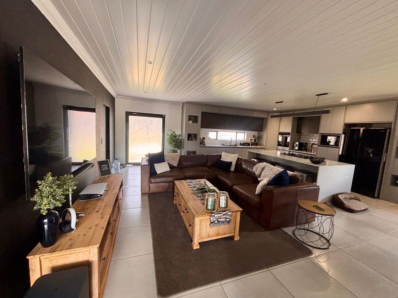 Spacious open-plan living area featuring a modern kitchen with a central island, built-in appliances, and contemporary finishes throughout.