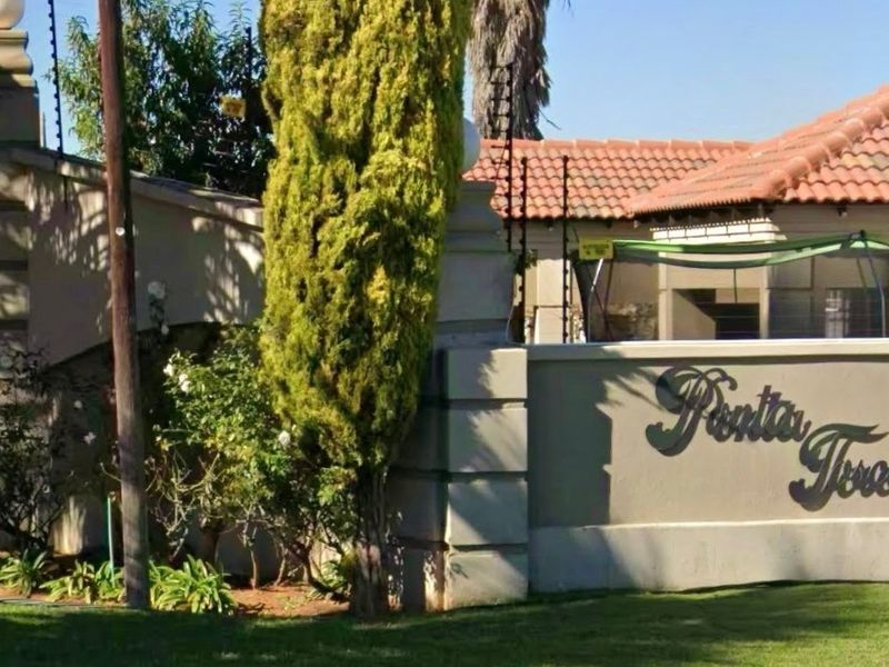 Front entrance view of the residential property featuring a masonry boundary wall with signage, tiled roofing, and integrated electric security fencing.