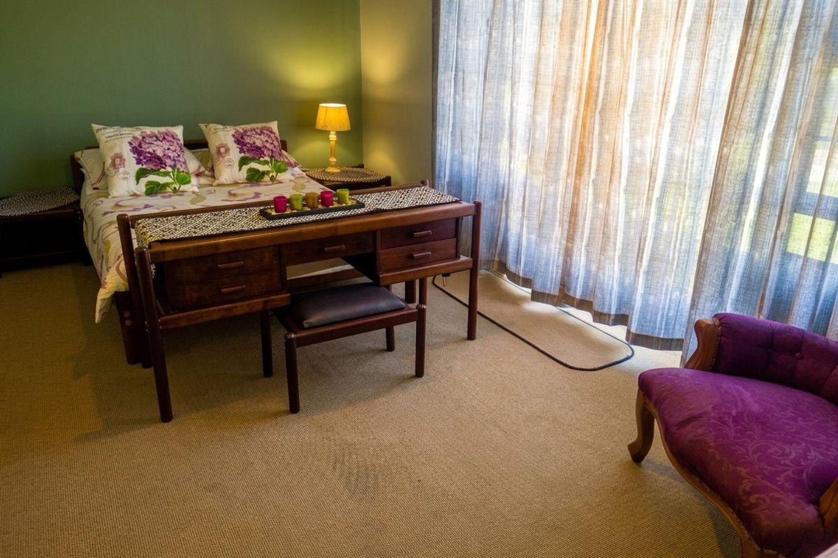 A bedroom featuring carpeted flooring and a large sliding glass door with curtains, providing natural light to the space.