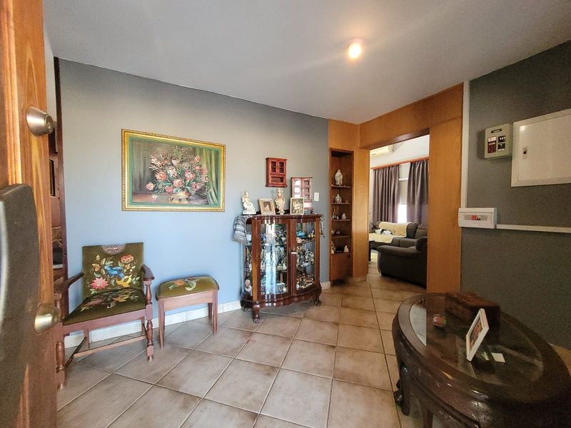 Entrance foyer featuring tiled flooring, built-in display shelving, and direct access to the adjacent living area.