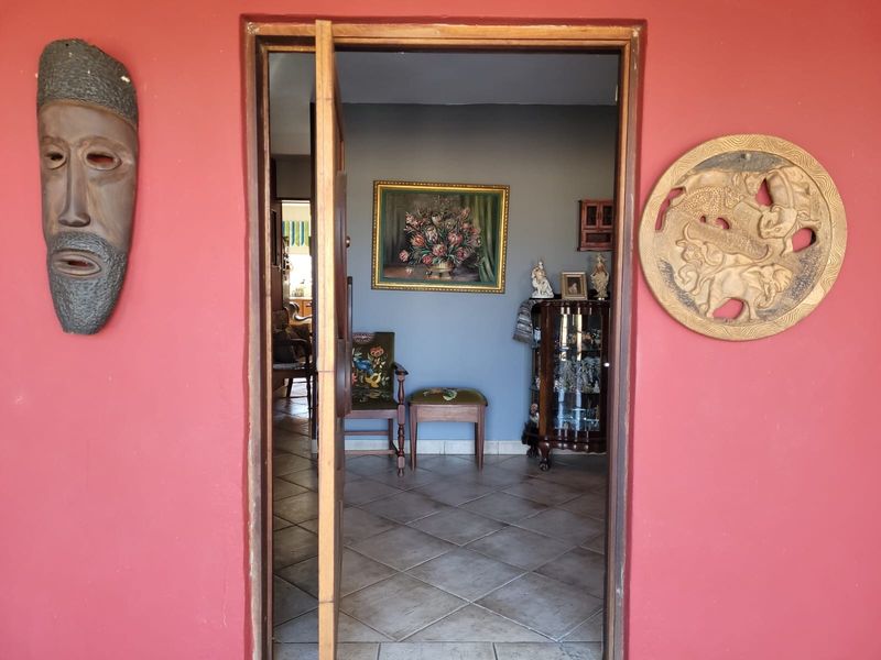 View through the main entrance doorway into the interior living space, featuring tiled flooring and a red exterior wall finish.