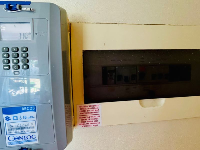 A wall-mounted prepaid electricity meter and electrical distribution board located within the property.