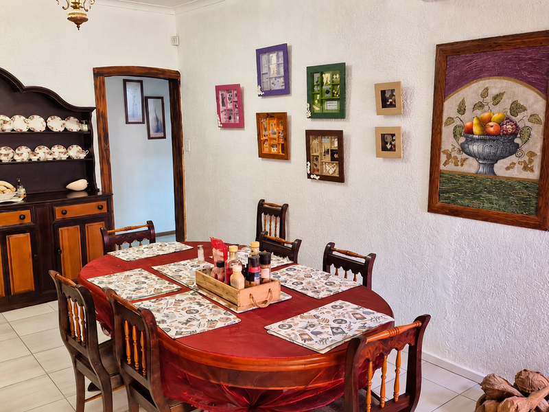 A traditional dining room featuring tiled flooring, a built-in wooden hutch, and coved ceiling details, offering a classic and functional space for family meals.