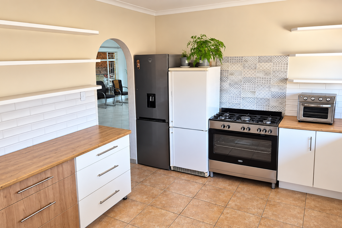 Modern kitchen featuring wooden countertops, white cabinetry, floating shelves, a gas stove with oven, and a decorative tiled backsplash.