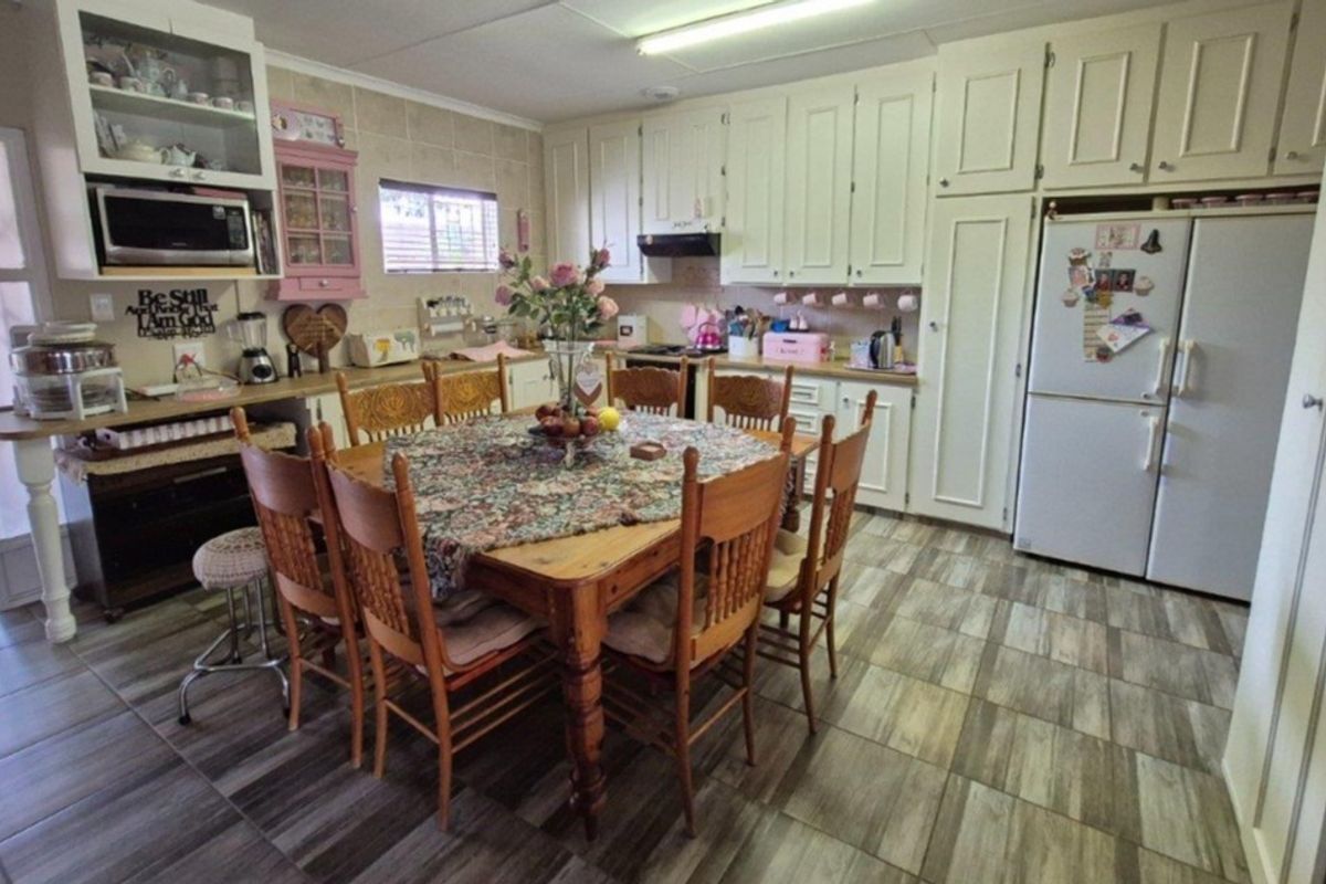A spacious kitchen featuring ample built-in cabinetry, a tiled backsplash, and integrated appliances, offering a functional layout with potential for modern updates.