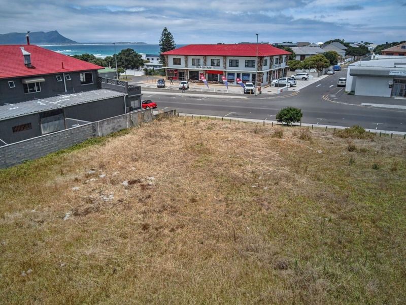 Aerial view of a vacant commercial plot situated in a prime location near the coast and local amenities.