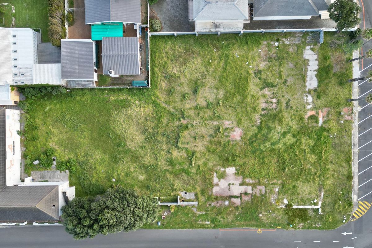 Aerial view of a vacant commercial land parcel featuring existing concrete foundations and street-level access, ready for new development.