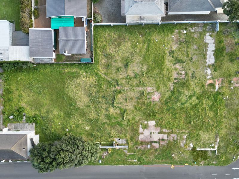Aerial view of a vacant commercial land parcel featuring existing concrete foundations and street-level access, ready for new development.