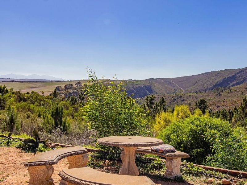 A scenic outdoor view overlooking a vast natural landscape with rolling hills and mountains in the distance.