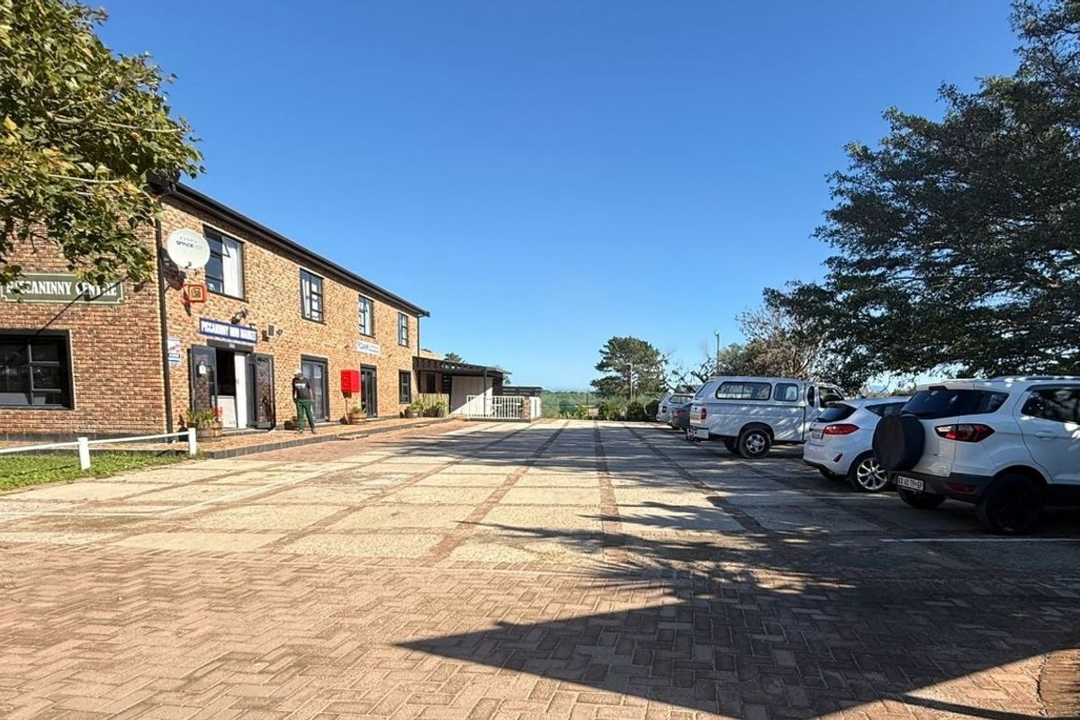 Front exterior view of the Piccaninny Centre commercial property, featuring a brick facade and a spacious paved parking area.