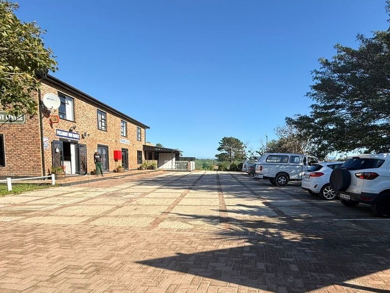 Front exterior view of the Piccaninny Centre commercial property, featuring a brick facade and a spacious paved parking area.