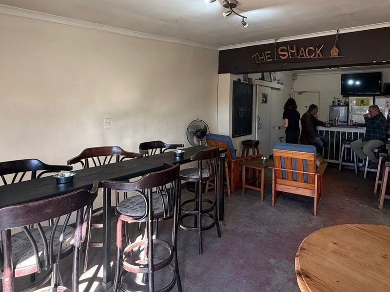 A casual bar area featuring a built-in service counter, open seating space, and basic interior finishes, suitable for renovation or modernization.