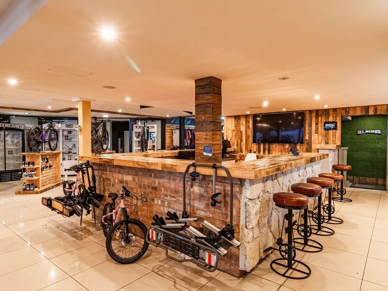 A well-maintained commercial bar area featuring a rustic brick and stone counter, tiled flooring, and integrated recessed lighting.