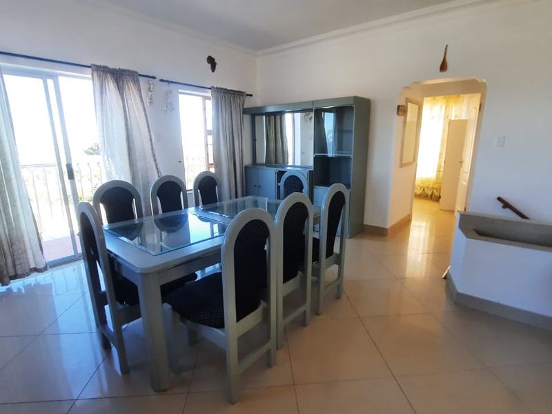 Dining room featuring tiled flooring, built-in cabinetry, and a sliding glass door providing access to the balcony.