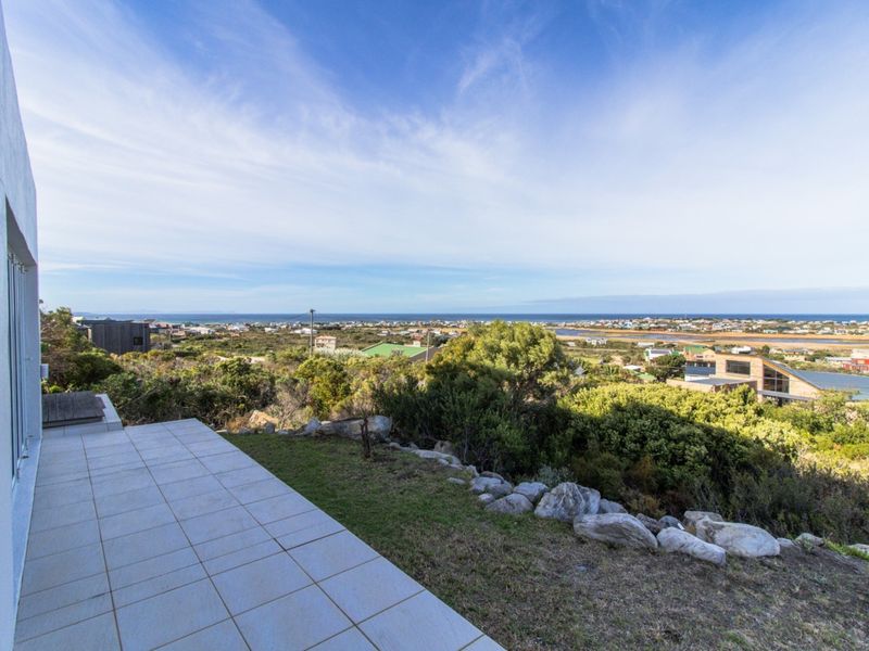 Elevated outdoor patio area featuring expansive coastal and landscape views over the surrounding neighborhood.