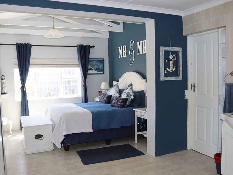 A bedroom featuring exposed ceiling beams, tiled flooring, and an integrated vanity area with a sink.