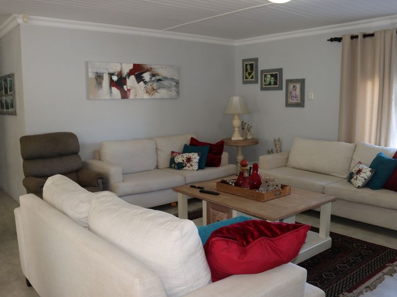 A comfortable living room featuring a tongue and groove ceiling, coving, and neutral wall finishes, providing a functional and inviting space.