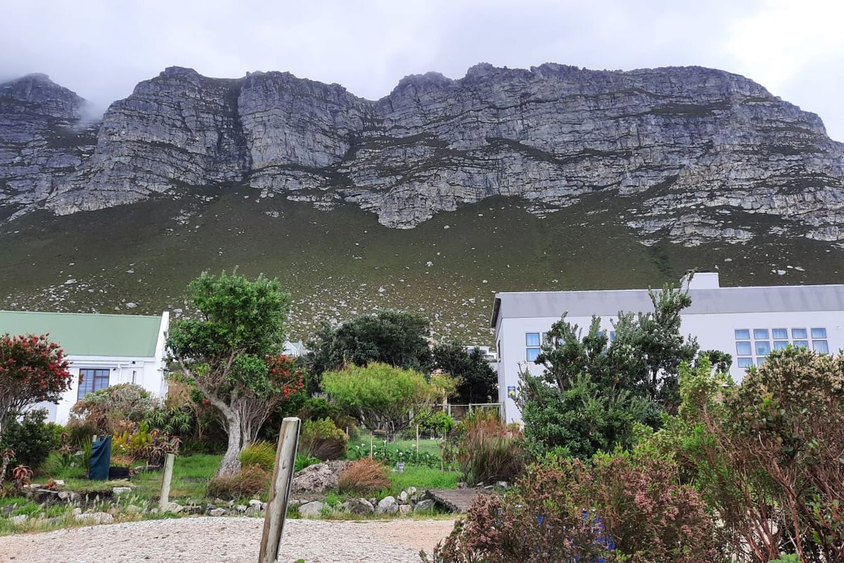 A scenic view of the property featuring a well-maintained garden set against a dramatic mountain backdrop.