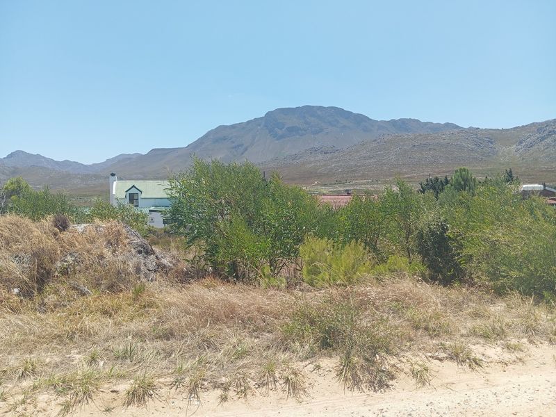 A scenic view of the surrounding landscape and mountains from the vacant residential property.