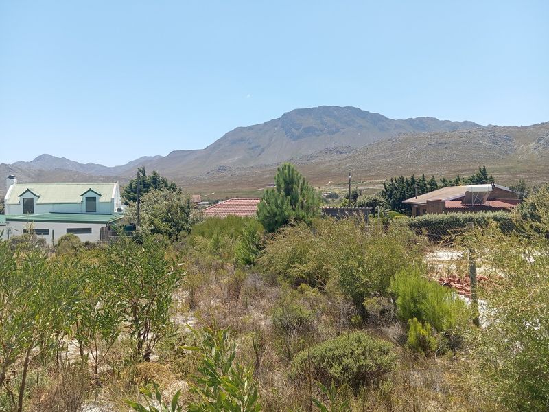 A scenic view of the surrounding residential area and mountain range from the vacant residential plot.