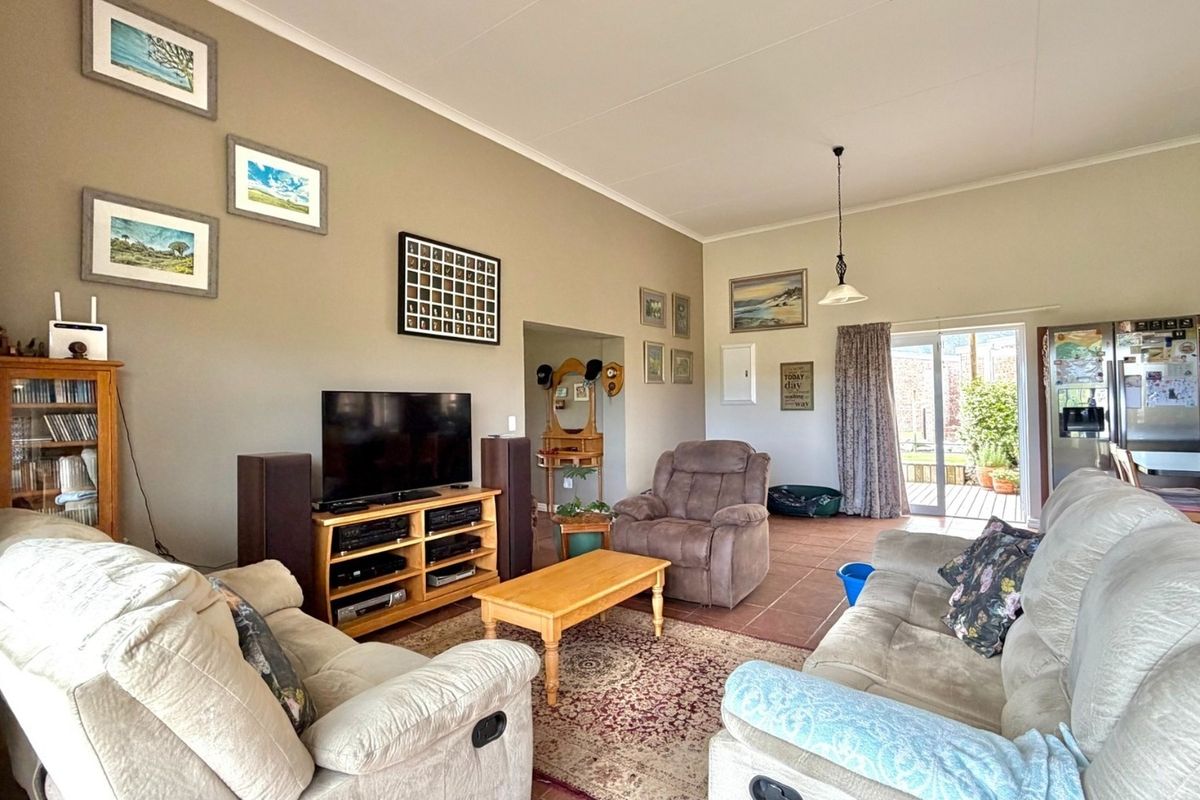 Spacious living room featuring tiled flooring, a pendant light, and a sliding glass door providing access to the outdoor patio area.