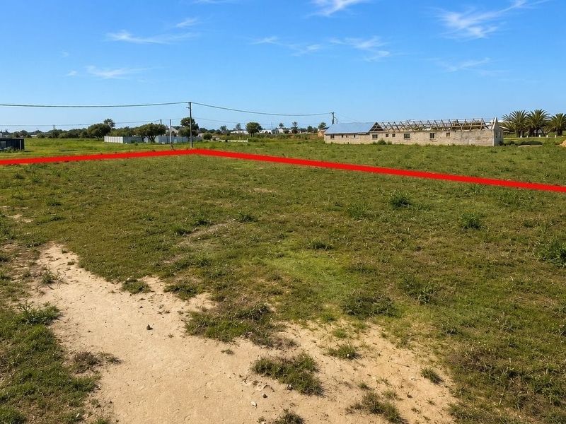 A vacant residential plot of land with clear boundary markings, situated in a developing neighborhood.