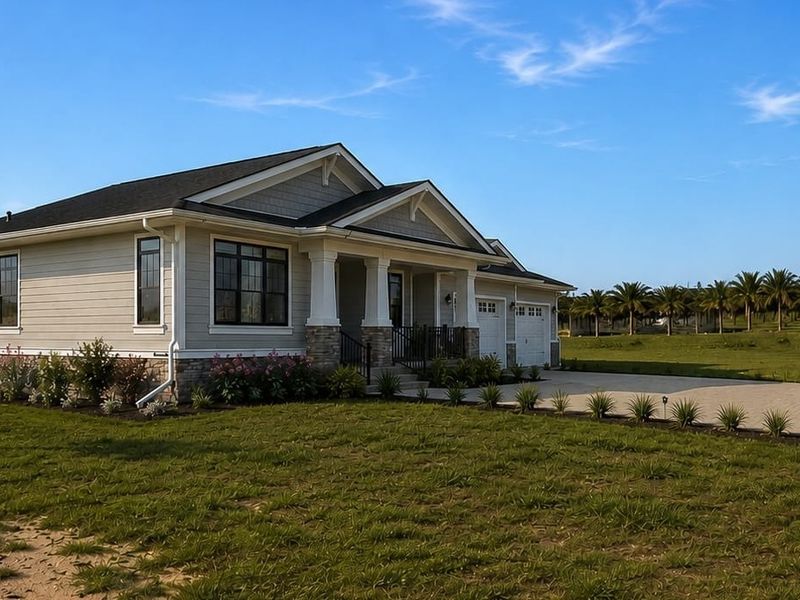 A well-maintained single-story residential home featuring stone veneer accents, lap siding, a covered front porch, and a spacious paver driveway.