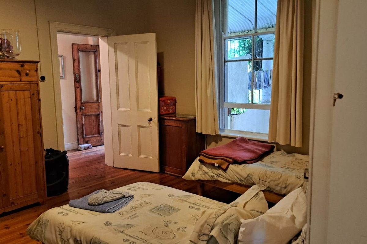 A bedroom featuring original timber flooring and a classic sash window, providing a warm and traditional atmosphere.
