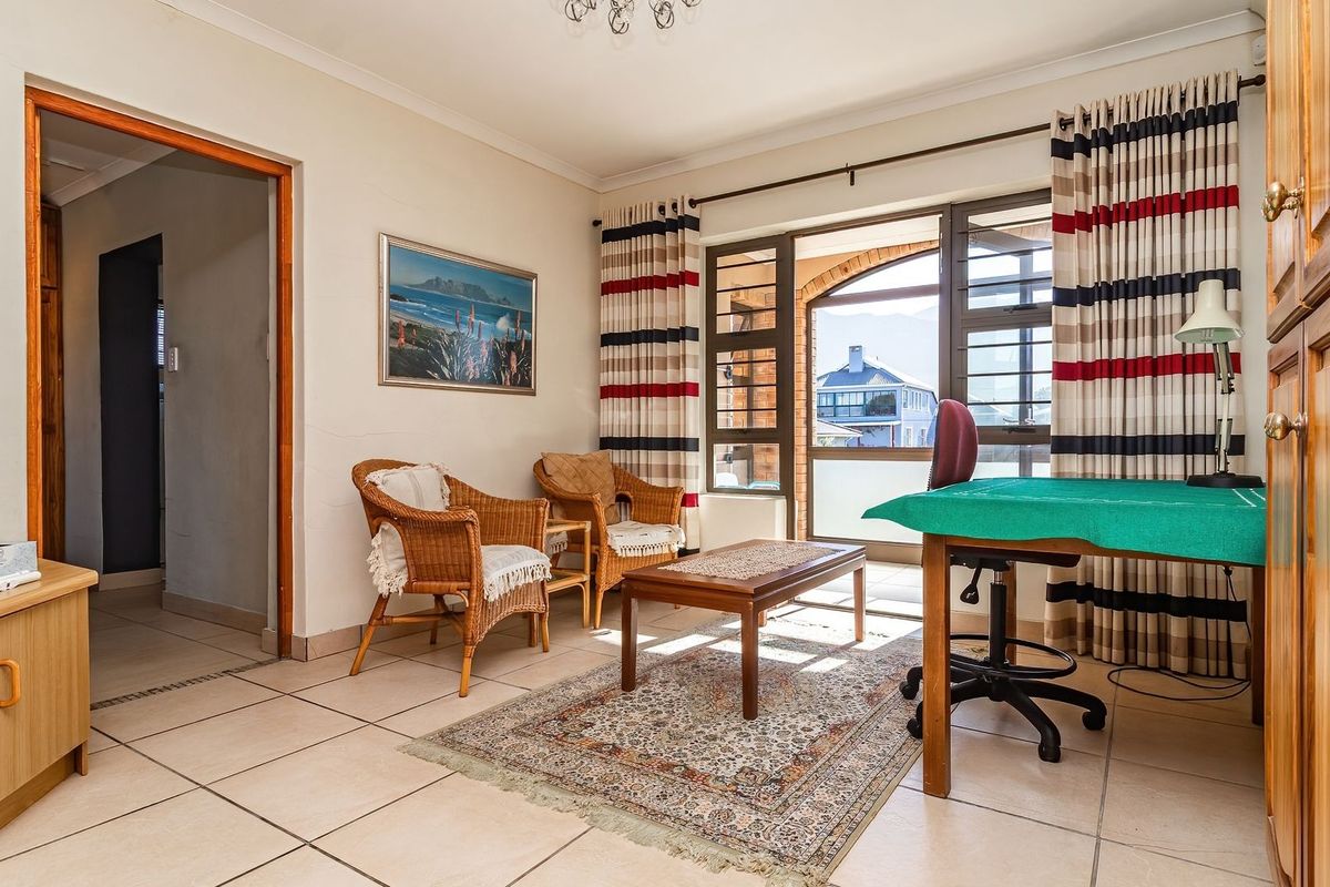 A living room featuring tiled flooring, built-in wooden cabinetry, and a sliding glass door providing access to an outdoor area.
