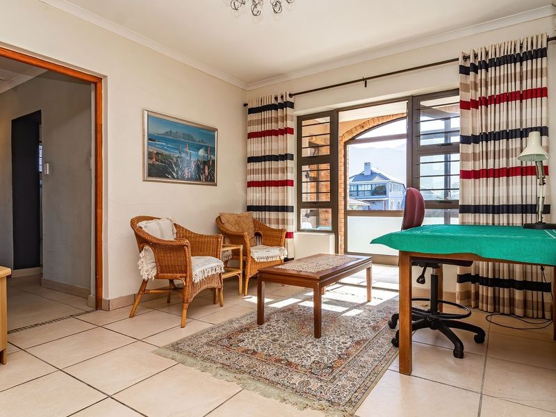 A living room featuring tiled flooring, built-in wooden cabinetry, and a sliding glass door providing access to an outdoor area.