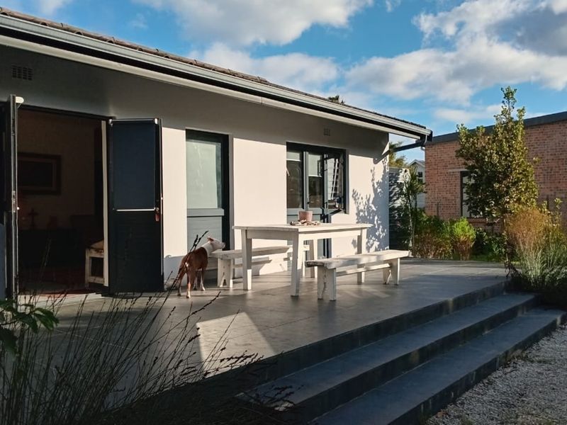 A well-maintained outdoor patio area featuring tiled flooring and stepped access, seamlessly connecting the interior living space to the rear garden.