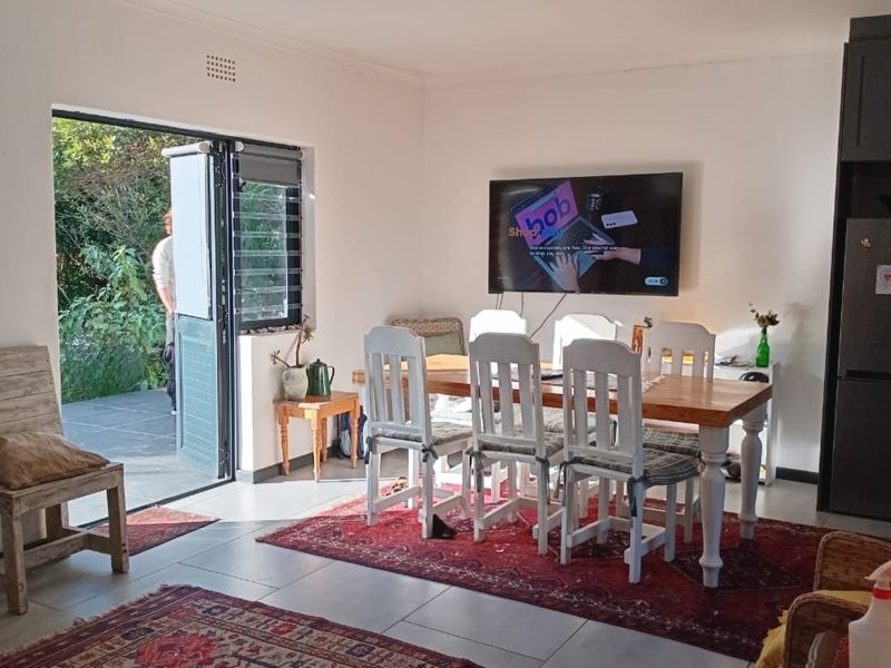 Open plan living and dining area featuring tiled floors, built-in cabinetry, and direct access to an outdoor patio through a sliding door.