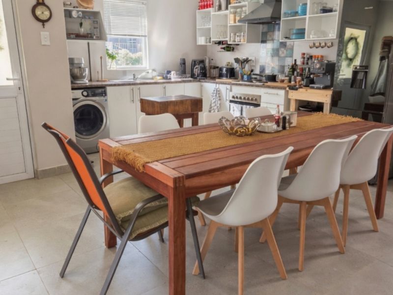 Open-plan kitchen and dining area featuring tiled floors, built-in cabinetry, and integrated laundry appliances, creating a functional and connected living space.