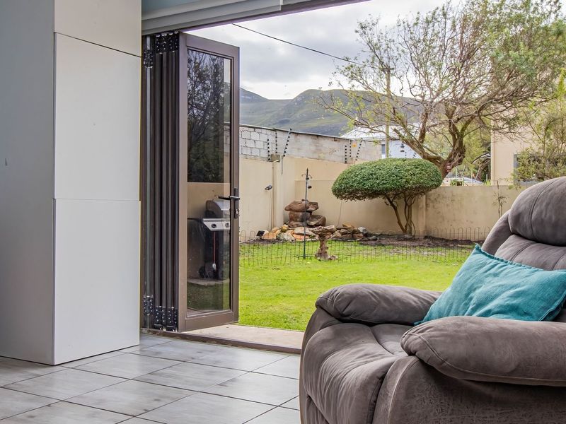 Indoor living space featuring large stacking doors that open onto a private garden area with mountain views.