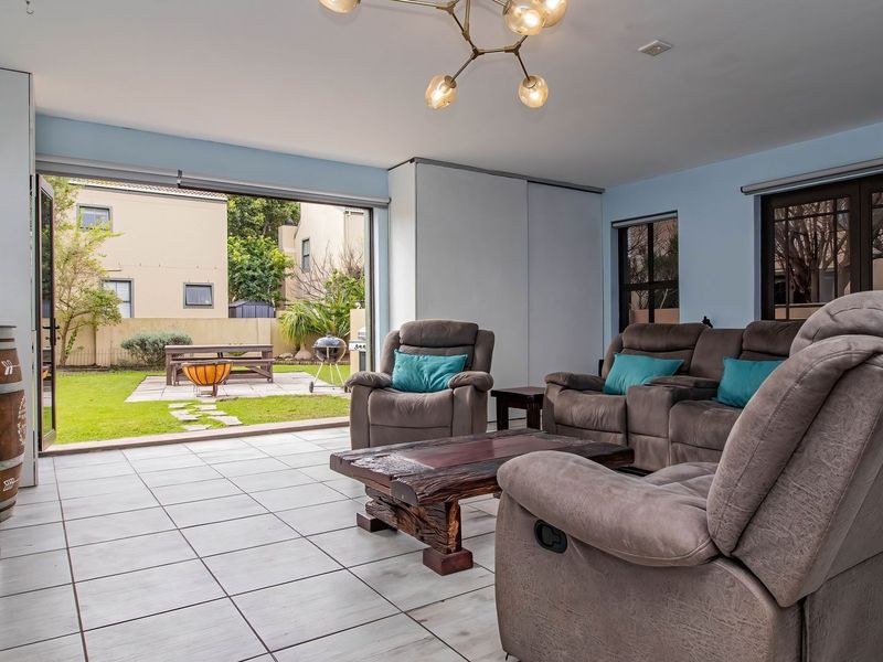 Spacious living room featuring tiled flooring and large sliding glass doors that provide seamless access to the rear garden area.